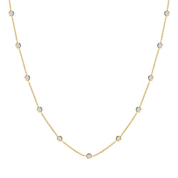 This delicate 14 karat gold necklace is handmade and features sparkling bezel - set stones. Diamond gold necklace.