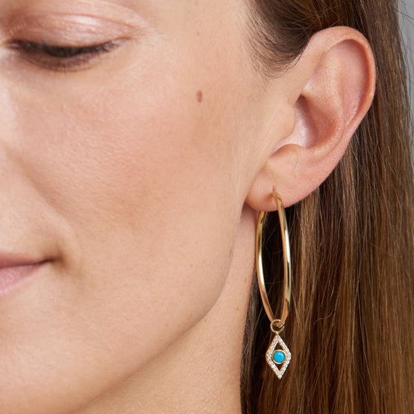 Two pairs of earrings in one! The 14 karat gold Evil Eye Turquoise Hoops feature handset diamonds and a turquoise gemstone. A glamorous statement hoop earring that feels light and comfortable on the ear. All day, all night.