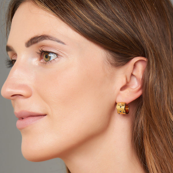 A magical and glamorous pair of gold earrings. These gold hoops feature white and blue topaz stones set in moons, stars and evil eye protection symbols. These gold earrings imbue you with magic and sparkle.