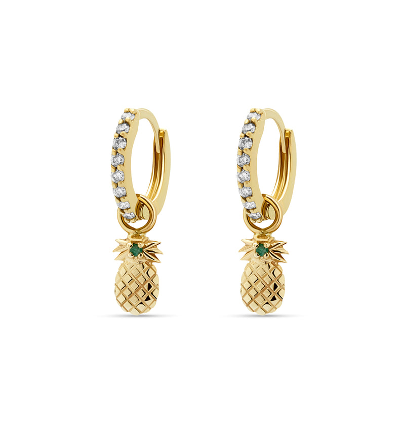 Our diamond gold huggie earrings in 14 karat gold feature pineapple charms with a handset green sapphire stone. A beautiful diamond earring that feels light and comfortable on the ear. 
